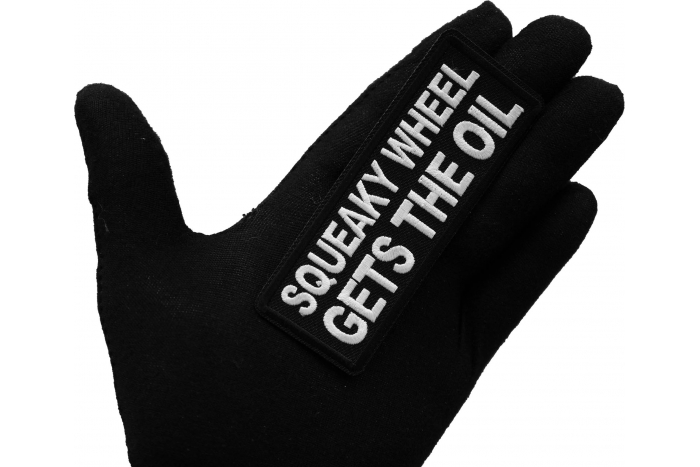 Squeaky Wheel Gets the Oil Patch, Biker Saying Patches shown on hand for size comparison