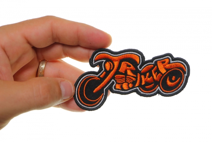 Triker Iron on Biker Patch In Orange and Black shown on hand for size comparison