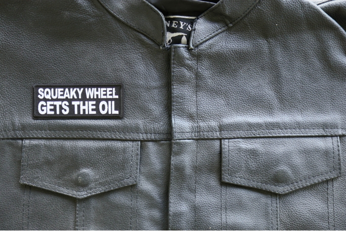 Squeaky Wheel Gets the Oil Patch, Biker Saying Patches shown on leather vest