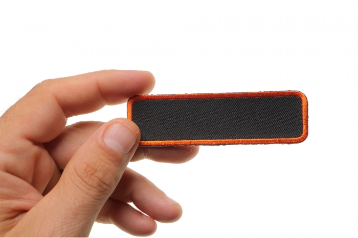 Blank Name Tag Patch Orange Border shown on hand for size comparison