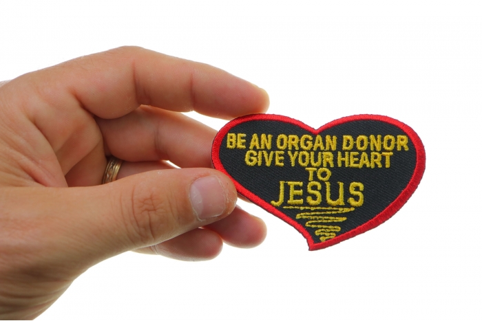 Be An Organ Donor Give Your Heart To Jesus Christian Patch shown on hand for size comparison