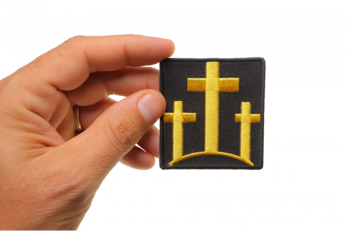 Black and Yellow Three Crosses Christian Patch shown on hand for size comparison
