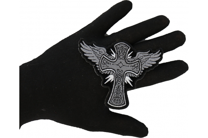 Cross with Wings Iron on Christian Patch shown on hand for size comparison