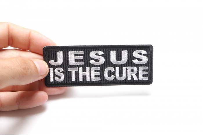 Jesus is The Cure Patch shown on hand for size comparison