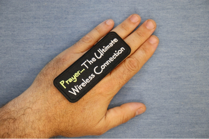 Prayer The Ultimate Wireless Connection Patch shown on hand for size comparison