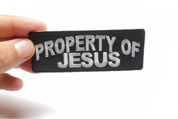 Property Of Jesus Christian Patch shown on hand for size comparison