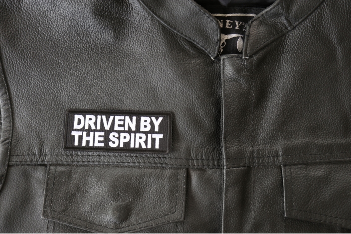 Driven by The Spirit Patch - 4x1.5 inch - Embroidered Iron on Patch shown on leather vest
