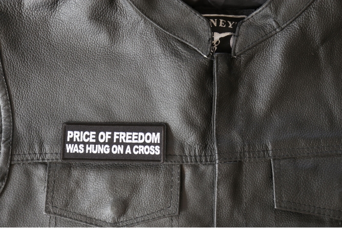 Price of Freedom was Hung on a Cross Patch - 4x1.5 inch - Embroidered Iron on Patch shown on leather vest