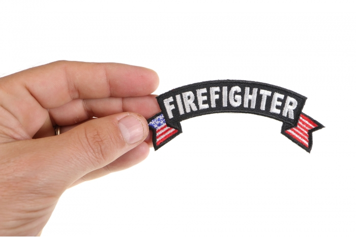 Firefighter US Flag Small Rocker Patch shown on hand for size comparison