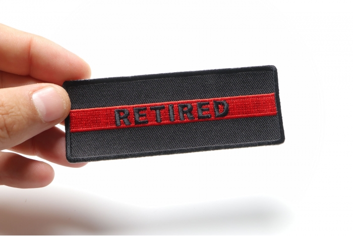 Retired Red Line Firefighter Patch shown on hand for size comparison