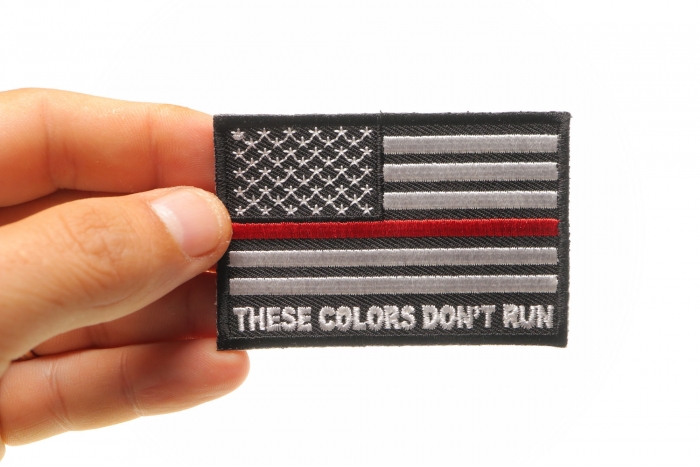 These Colors Don't Run Red Line US Flag Patch shown on hand for size comparison