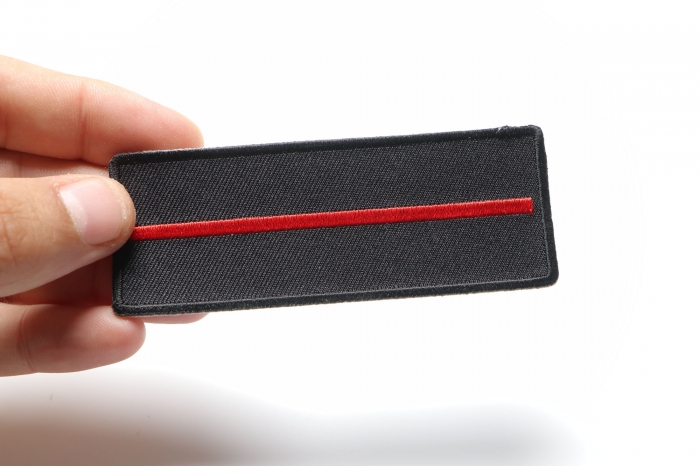 Thin Red Line Patch For Firefighters shown on hand for size comparison