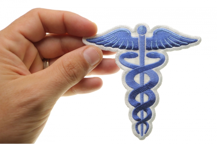 Medic Symbol Iron on Patch Blue shown on hand for size comparison