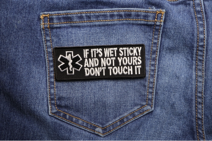 If It's Wet Sticky and Not Yours Fun EMT Patch shown on jeans