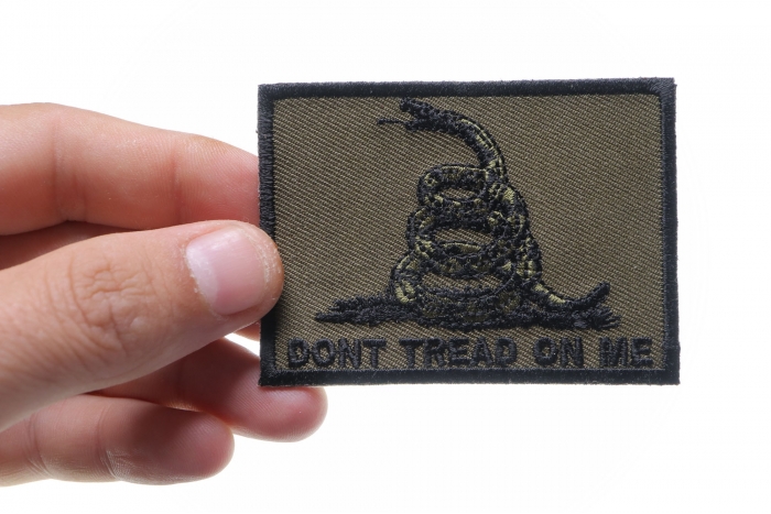 Don't Tread On Me Gadsden Flag Black Over Army Green Patch shown on hand for size comparison