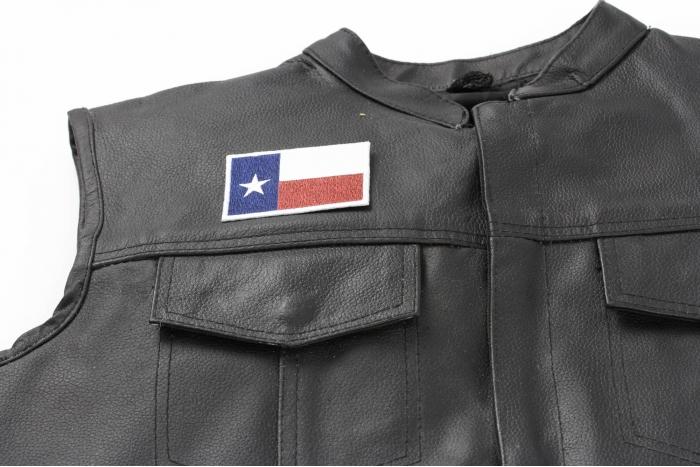 Subdued Texas Flag Patch - 3x2 inch. Embroidered Iron on Patch shown on leather vest