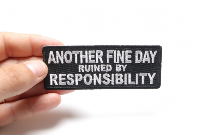 Another Fine Day Ruined By Responsibility Funny Iron on Patch shown on hand for size comparison