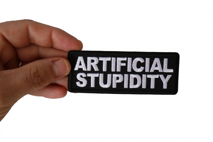 Artificial Stupidity Funny Iron on Patch shown on hand for size comparison