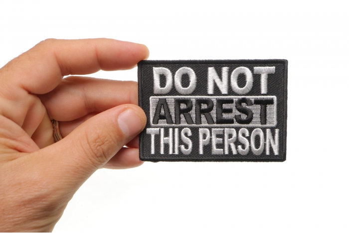 Do Not Arrest This Person Funny Iron on Patch shown on hand for size comparison