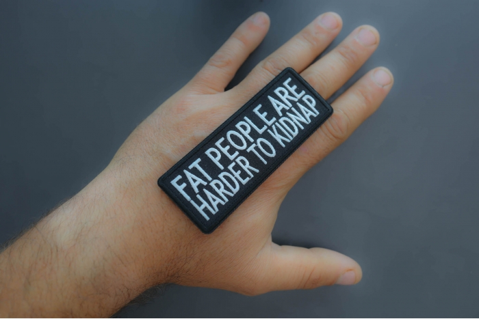 Fat People Are Harder To Kidnap Funny Iron on Patch shown on hand for size comparison