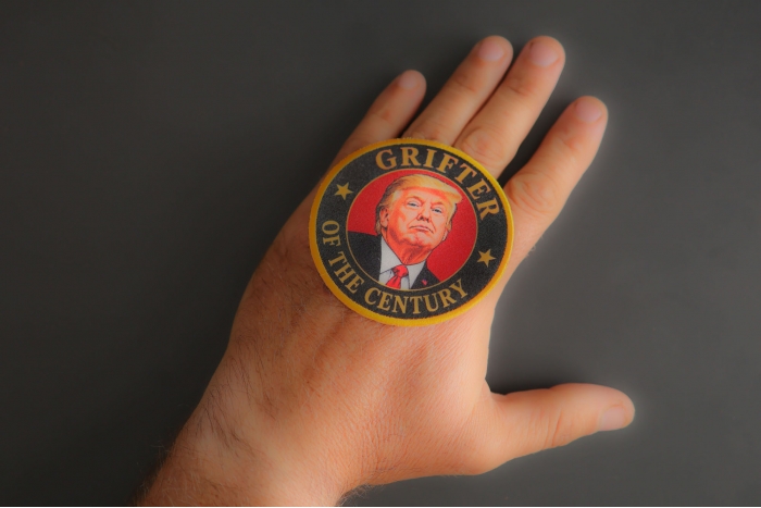 Grifter Of The Century Trump Patch shown on hand for size comparison