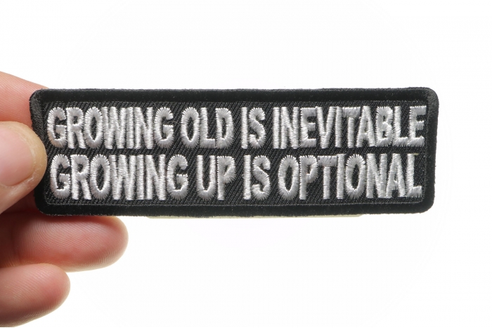 Growing Old Is Inevitable Growing Up Is Optional Funny Iron on Patch shown on hand for size comparison
