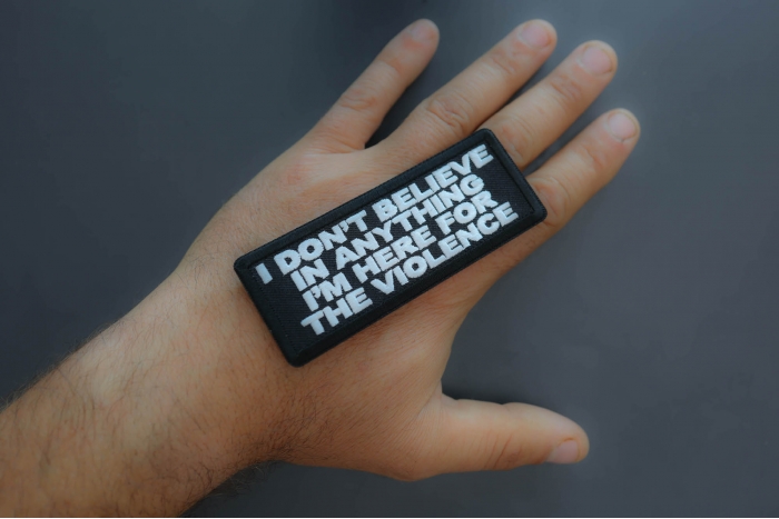 I don't believe in anything I'm here for the violence Patch shown on hand for size comparison