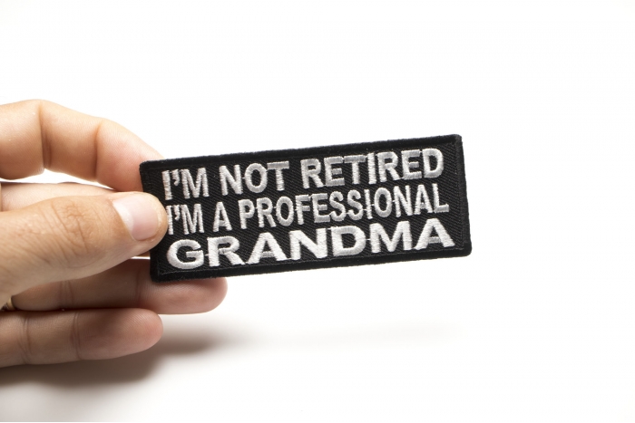 I'm Not Retired I'm A Professional Grandma Funny Iron on Patch shown on hand for size comparison