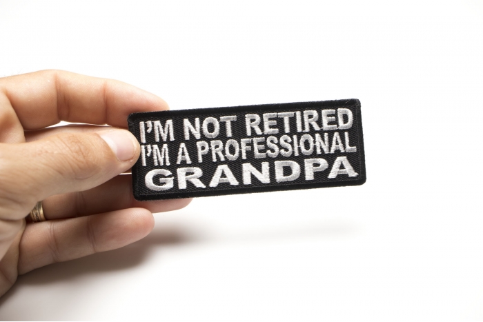 I'm Not Retired I'm A Professional GrandPa Funny Iron on Patch shown on hand for size comparison