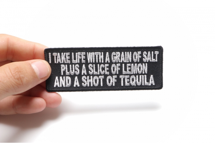 I Take Life With A Grain Of Salt Slice Of Lemon and Shot Of Tequila Funny Iron on Patch shown on hand for size comparison
