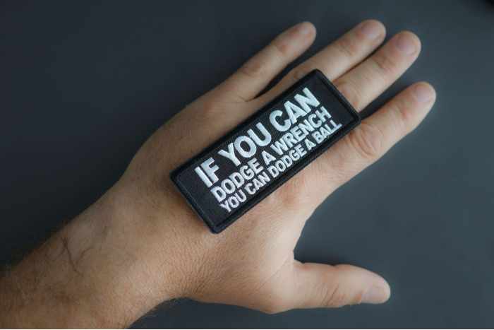 If You Can Dodge A Wrench You Can Dodge A Ball Patch shown on hand for size comparison