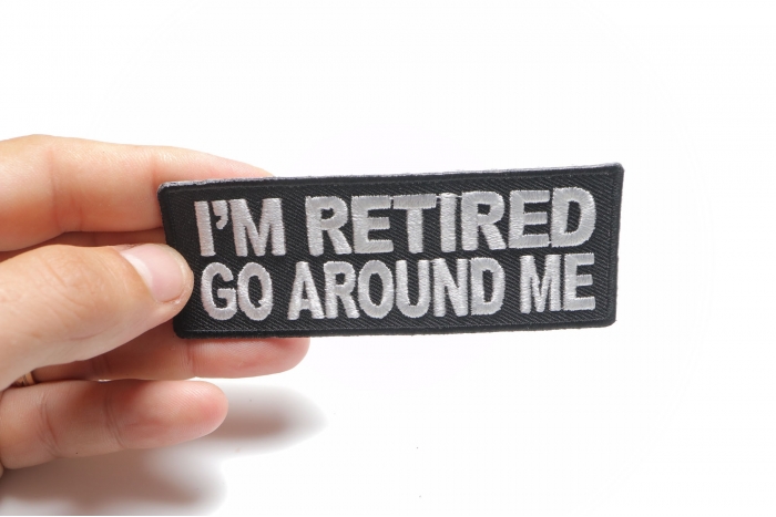I'm Retired Go Around Me Funny Iron on Patch shown on hand for size comparison