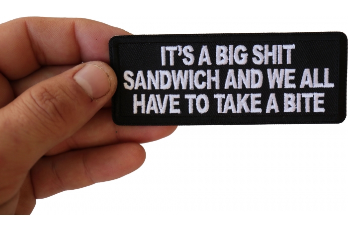 It's a Big Shit Sandwich and We all have to take a Bite Funny Iron on Patch shown on hand for size comparison