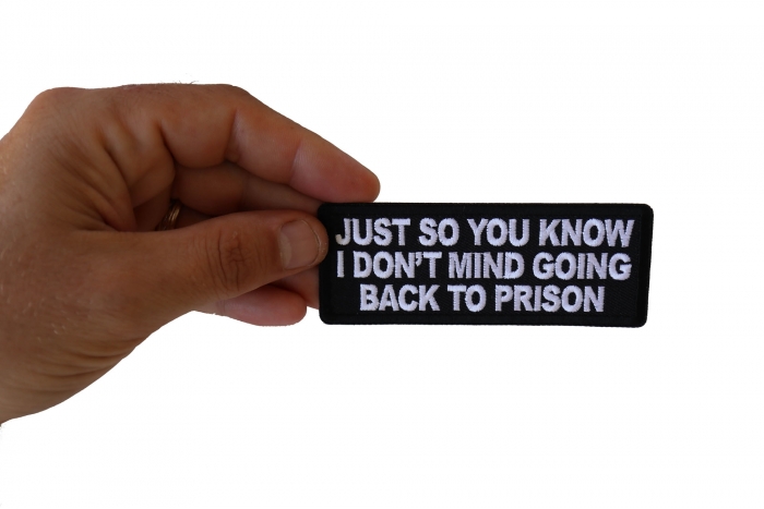 Just So You Know I don't Mind Going Back to Prison Funny Iron on Patch shown on hand for size comparison