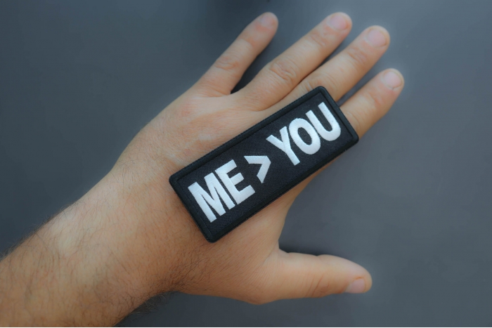 Me greater than you patch shown on hand for size comparison