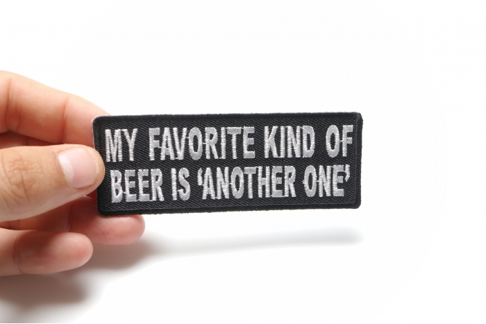 My Favorite Kind Of Beer Is Another One Funny Iron on Patch shown on hand for size comparison