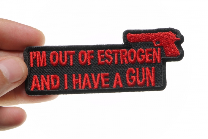 I'm Out Of Estrogen and I Have A Gun Funny Iron on Patch shown on hand for size comparison