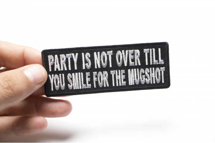 Party Is Not Over Till You Smile For The Mugshot Funny Iron on Patch shown on hand for size comparison