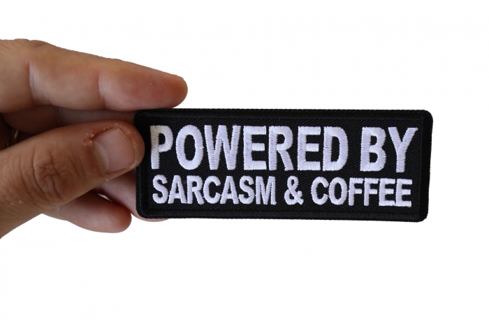 Powered By Sarcasm and Coffee Funny Iron on Patch shown on hand for size comparison