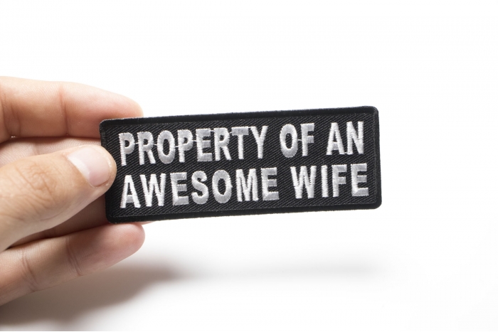 Property Of An Awesome Wife Funny Iron on Patch shown on hand for size comparison