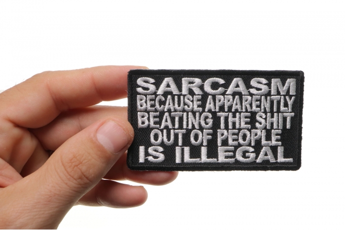 Sarcasm Because Beating Up People Is Illegal Funny Iron on Patch shown on hand for size comparison