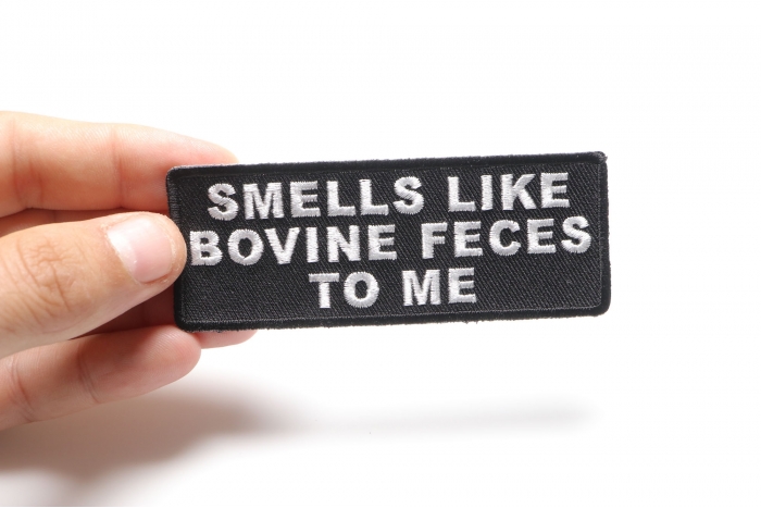 Smells Like Bovine Feces To Me Funny Iron on Patch shown on hand for size comparison