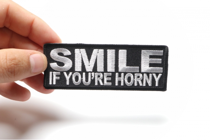 Smile If You're Horny Funny Iron on Patch shown on hand for size comparison