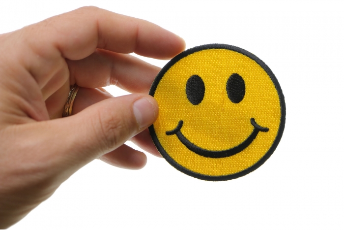 Smiley Face Funny Iron on Patch shown on hand for size comparison