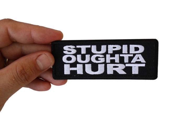 Stupid Oughta Hurt Funny Iron on Patch shown on hand for size comparison