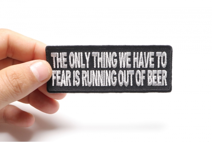 The Only Thing We Have To Fear Is Running Out Of Beer Funny Iron on Patch shown on hand for size comparison