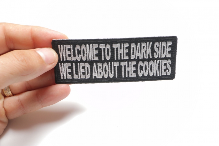 Welcome To The Dark Side We Lied About The Cookies Funny Iron on Patch shown on hand for size comparison
