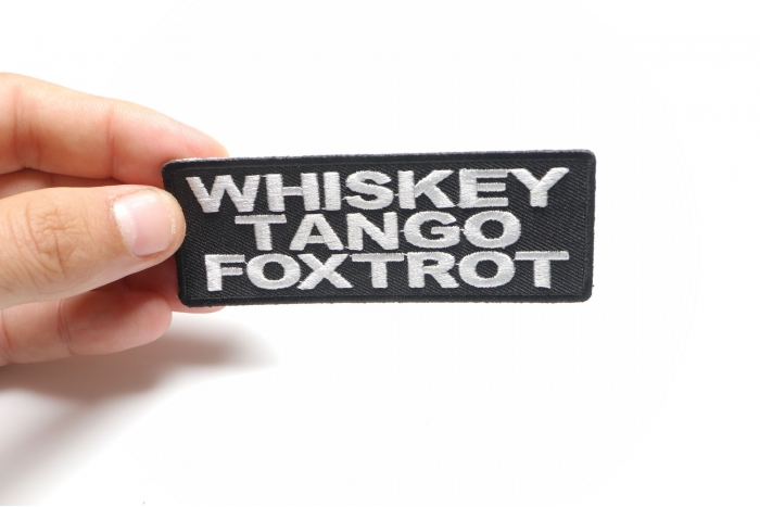 Whiskey Tango Foxtrot Funny Iron on Patch shown on hand for size comparison