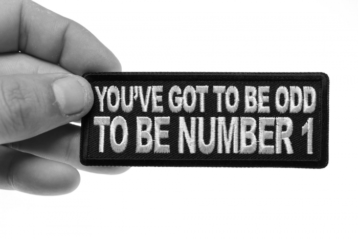 You've Got to be odd to be Number 1 Patch, Funny Saying Patches shown on hand for size comparison