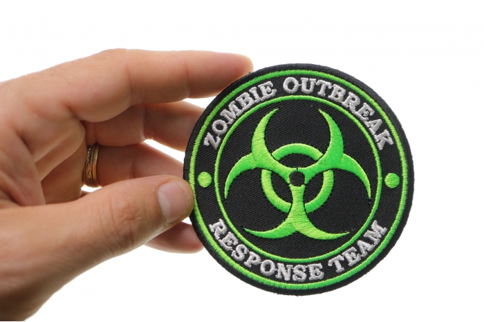 Zombie OutBreak Response Team Green Funny Iron on Patch shown on hand for size comparison
